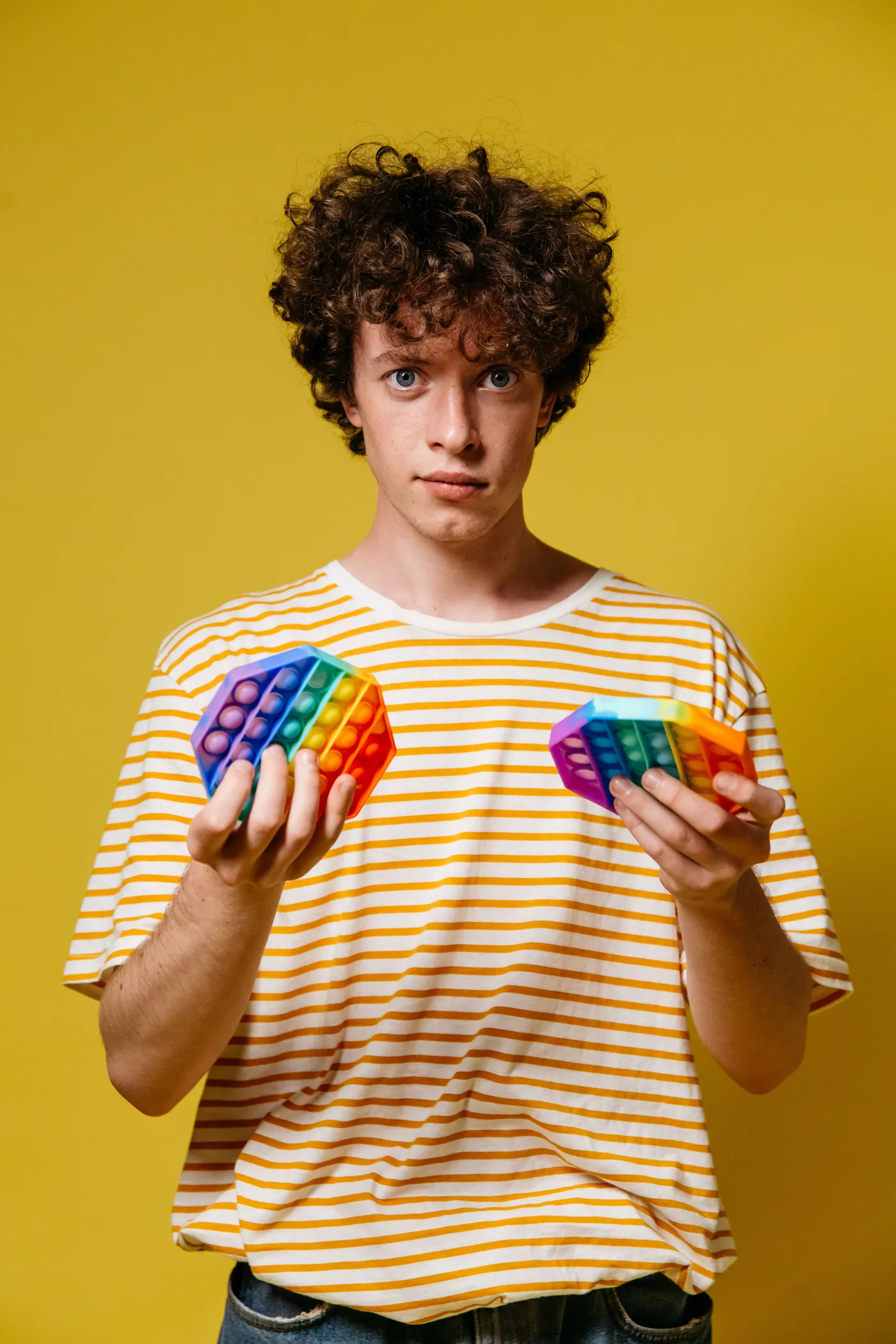Une personne tient deux jouets sensoriels colorés, un dans chaque main.
